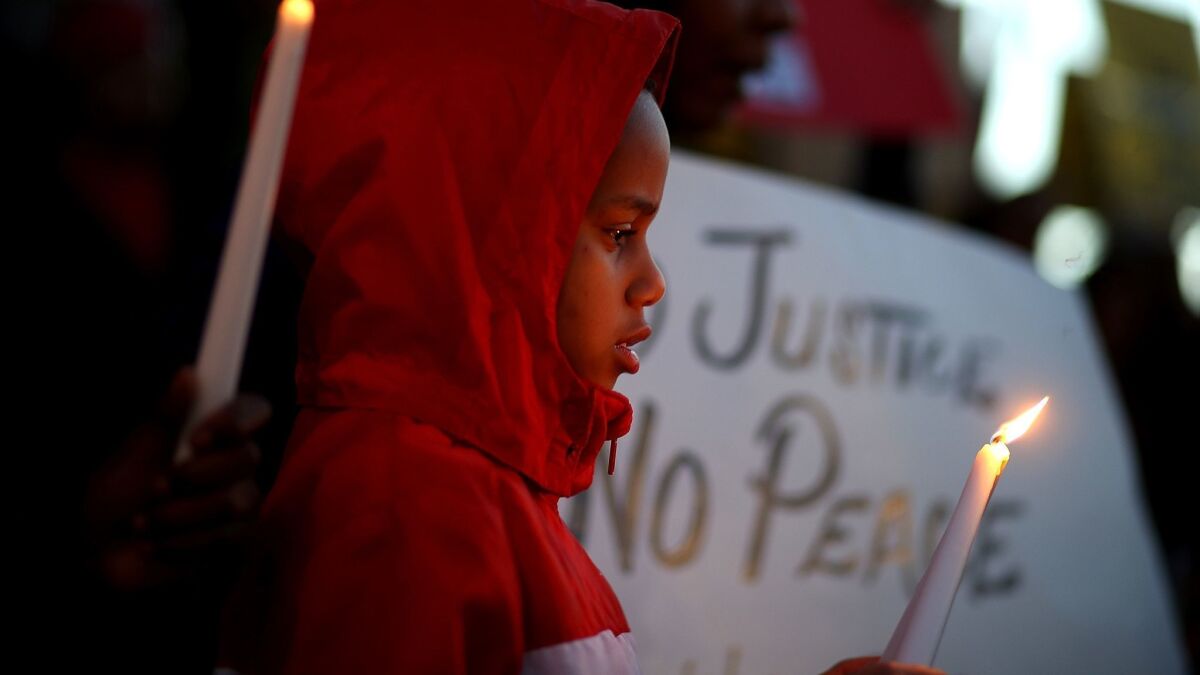 Black Lives Matter protesters hold candles during a vigil and demonstration on March 23, in Sacramento, California.