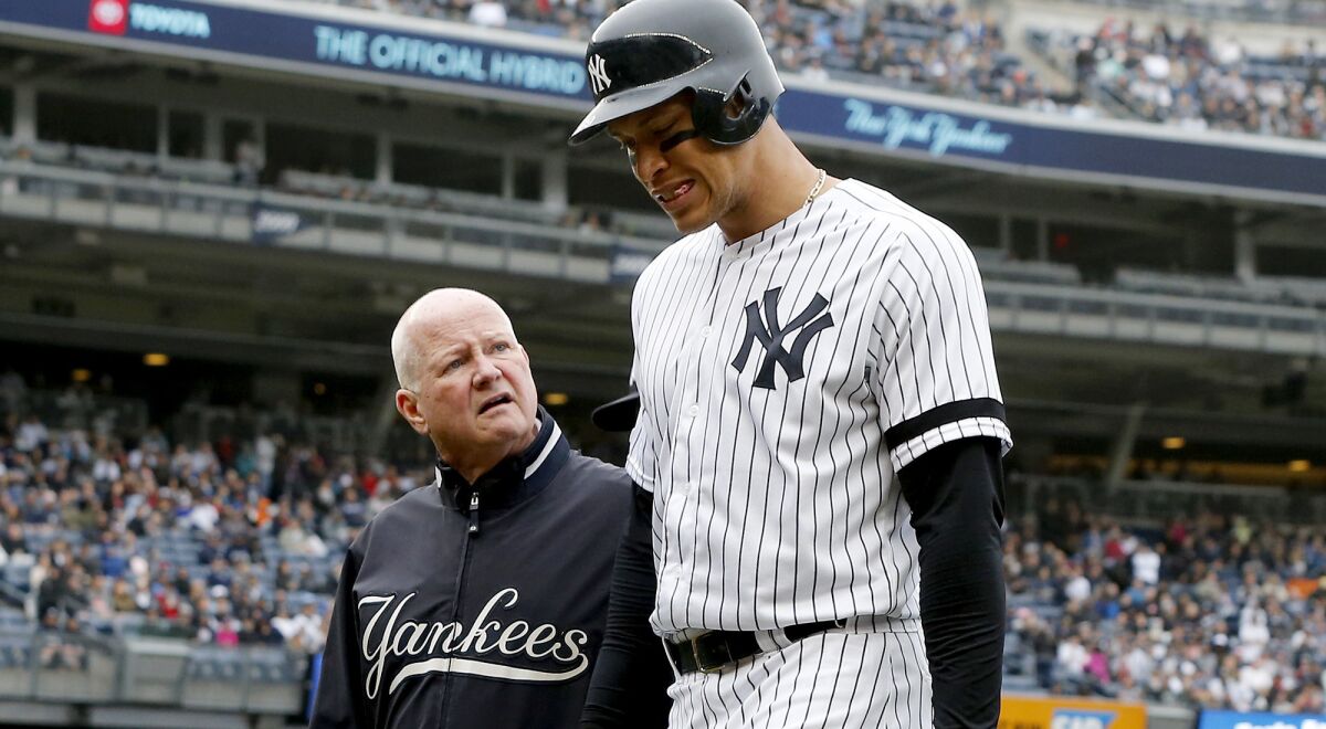 Yankees outfielder Aaron Judge leaves the game with trainer Steve Donohue during the sixth inning Saturday.