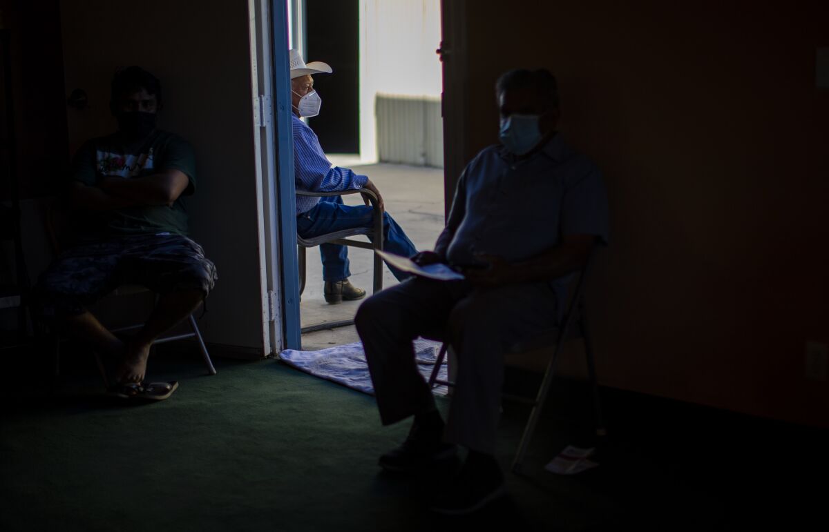 Farmworkers wait to get a COVID-19 vaccine.