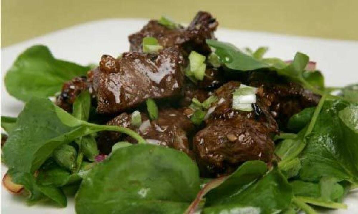 ONE-DISH MEAL: Hot, sautéed beef over a cool watercress salad.