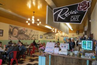 A sign and donation bucket near the cash register at Rosie's Cafe in Escondido on Monday raises awareness and money for owner Kaitlyn Rose Pilsbury, 33, who was critically injured Dec. 21 in a hit-and-run accident in Vista.
