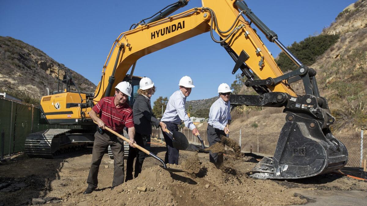 Laguna Beach City Council members Steve Dicterow, left, Toni Iseman, Bob Whalen and Rob Zur Schmiede toss a shovel full of dirt during a ground-breaking ceremony for the Village Entrance project in 2018.