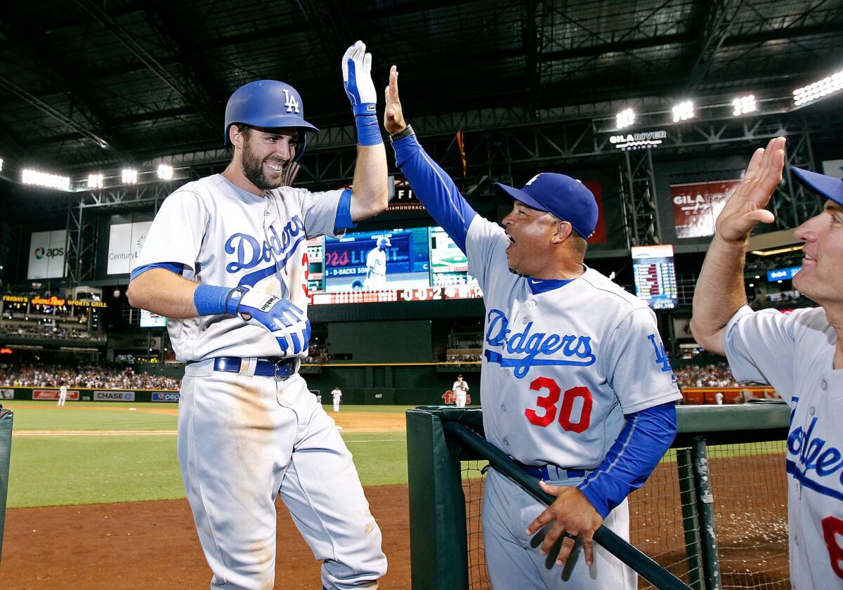 Dodgers infielder Chris Taylor (3) is congratulated by Manager Dave Roberts (30) after hitting a grand slam against the Diamondbacks during a game July 15 in Phoenix.