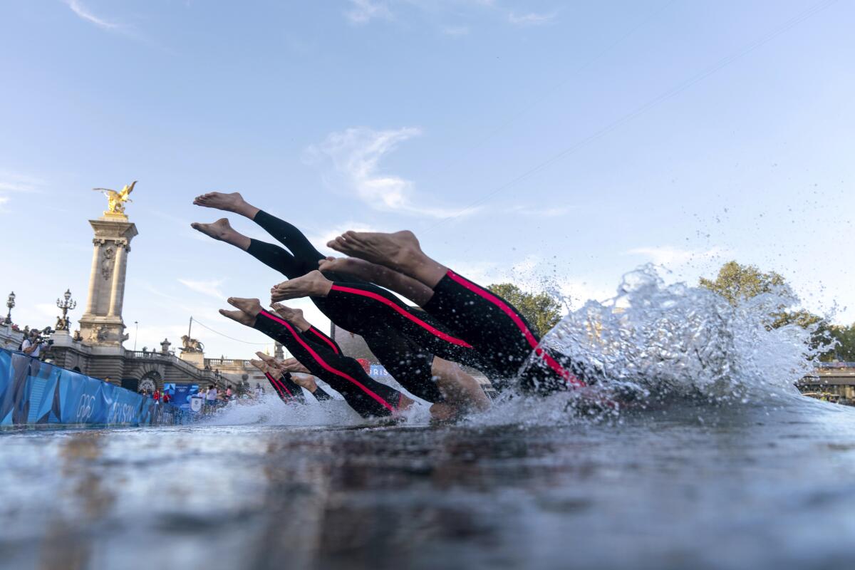 Competitors dive into the Seine River during the Olympic men's 10-kilometer race on Aug. 9.