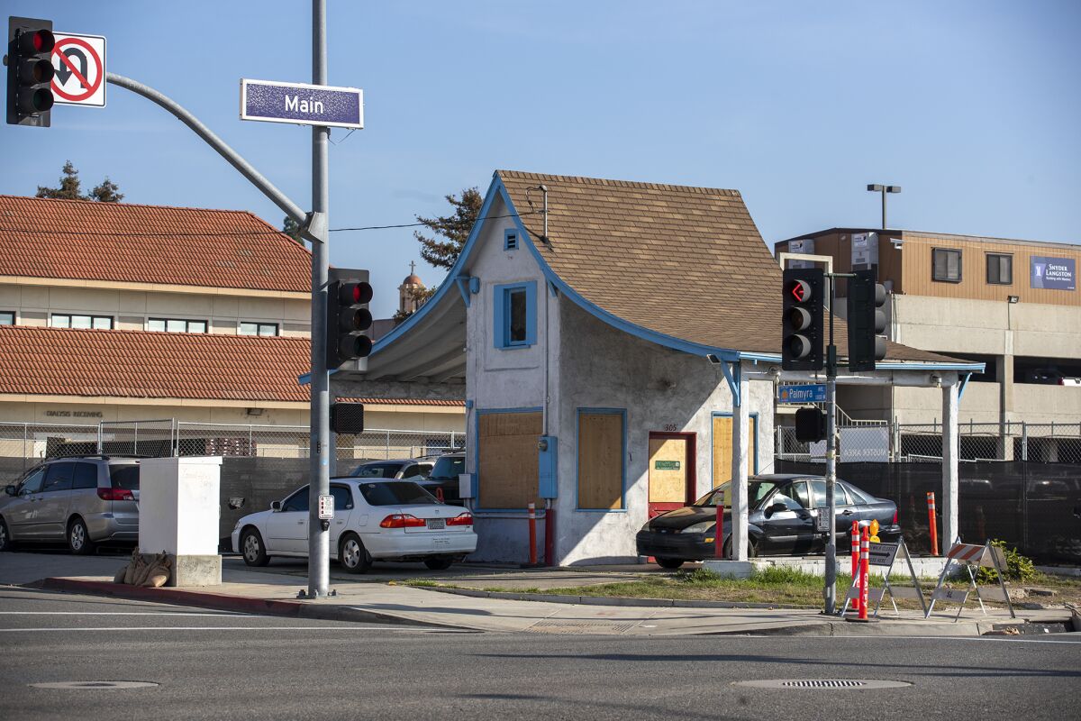 A gas station from the 1920s sits empty and boarded up in Orange.