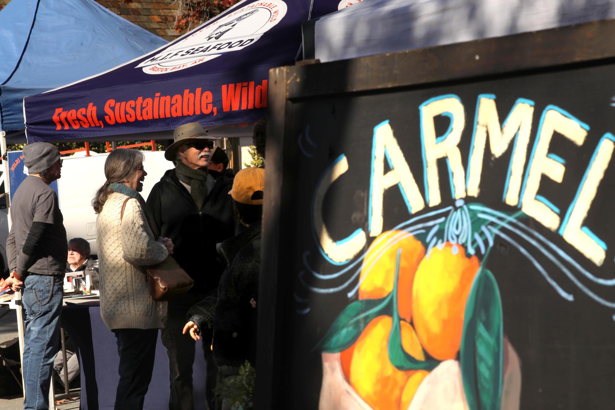 Shoppers visit the weekly Carmel Farmers Market in Carmel-by-the-Sea.
