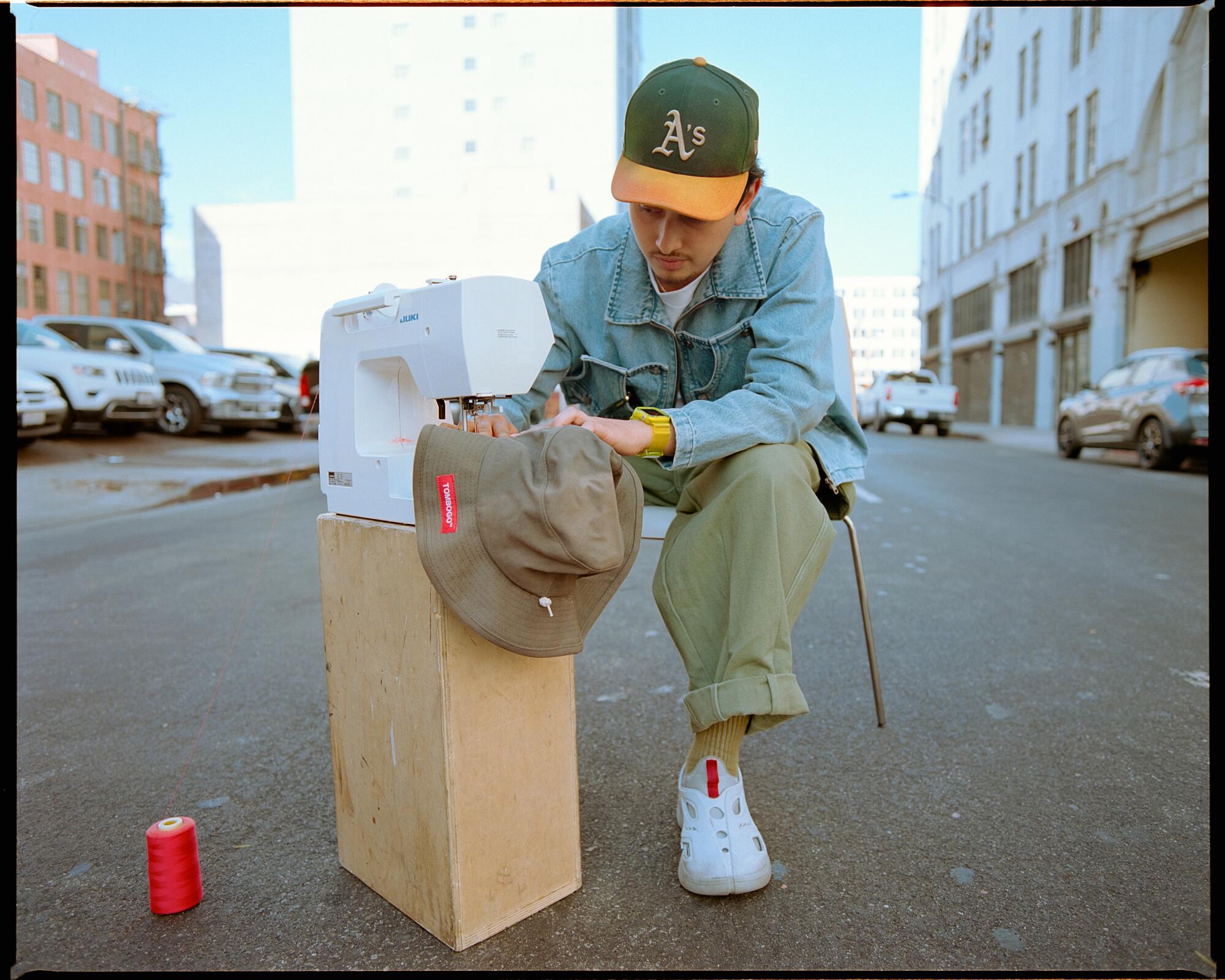 Photo of Tommy Bogo sewing on a street in DTLA.
