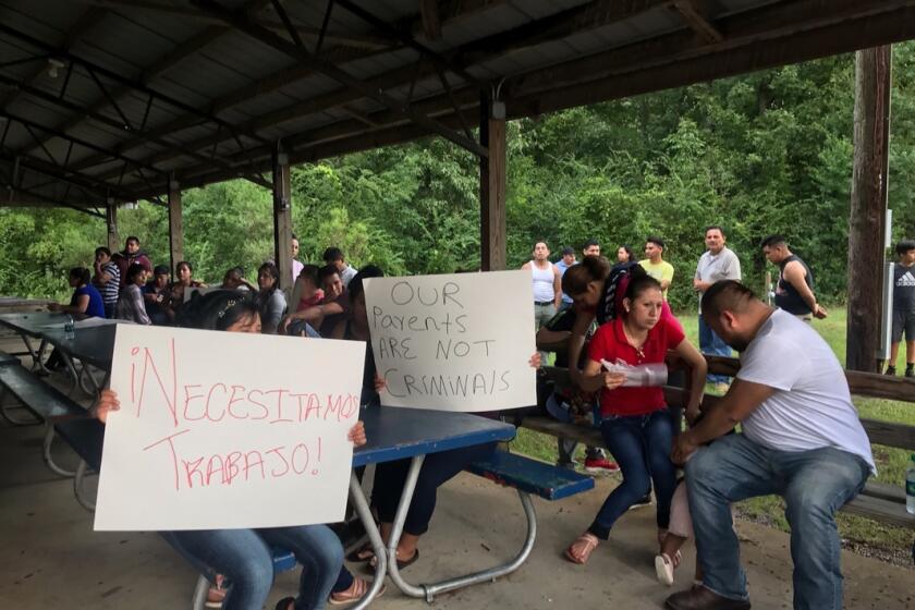 Trabajadores de PH Foods y simpatizantes de su causa sostienen carteles que dicen, "¬°Necesitamos trabajo!" y "Nuestros padres no son criminales", el martes 13 de agosto del 2019 en Morton, Mississippi, despu√©s de que las autoridades migratorias arrestaran a casi 100 trabajadores en esta planta de procesamiento de pollos. (AP Foto/Terry Truett)