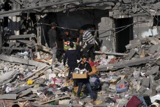 Palestinians salvage belongings from the destroyed Al-Gatshan family building after an Israeli strike in Nusseirat refugee camp, central Gaza Strip, Monday, Dec. 18, 2023. (AP Photo/Adel Hana)