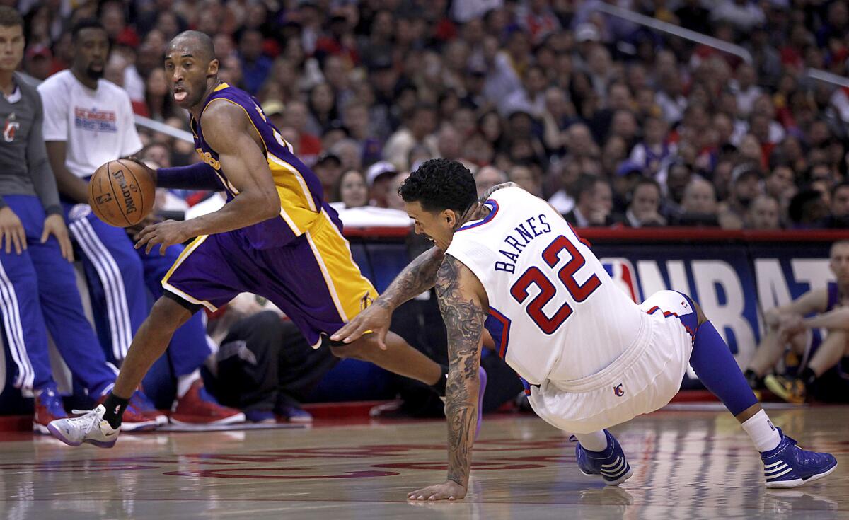 Clippers forward Matt Barnes loses his balance as Lakers guard Kobe Bryant drives around him during a game on April 7, 2013.
