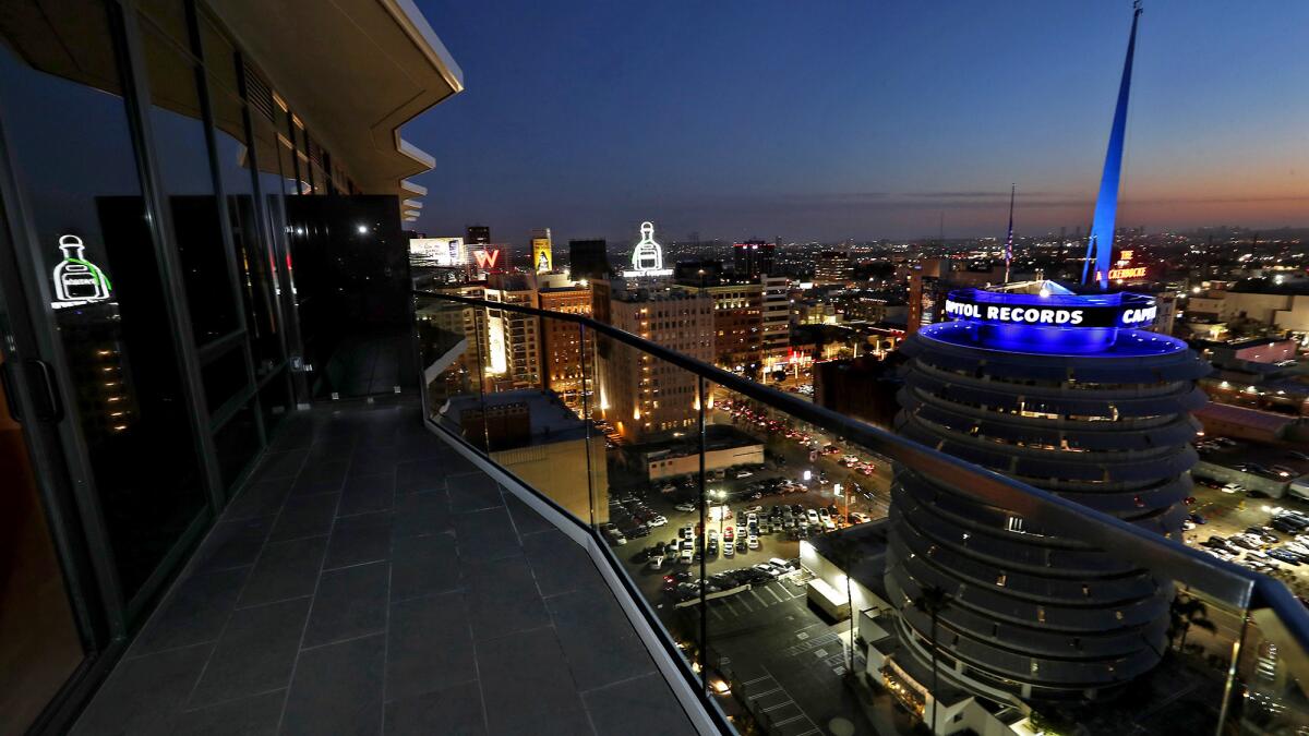 A balcony view at night from a penthouse suite at Argyle House, an 18-story luxury apartment tower in Hollywood near the Capitol Records Building, right.