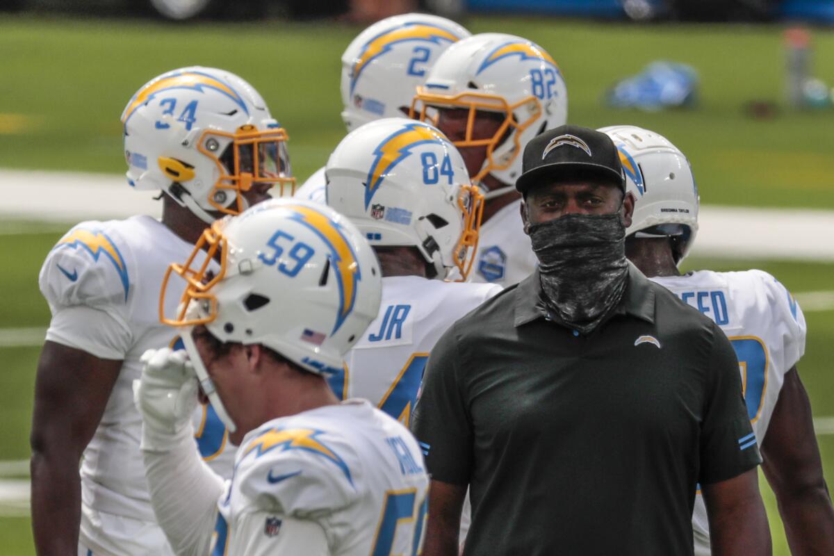 Chargers coach Anthony Lynn stands with players before a game against the Kansas City Chiefs in September.
