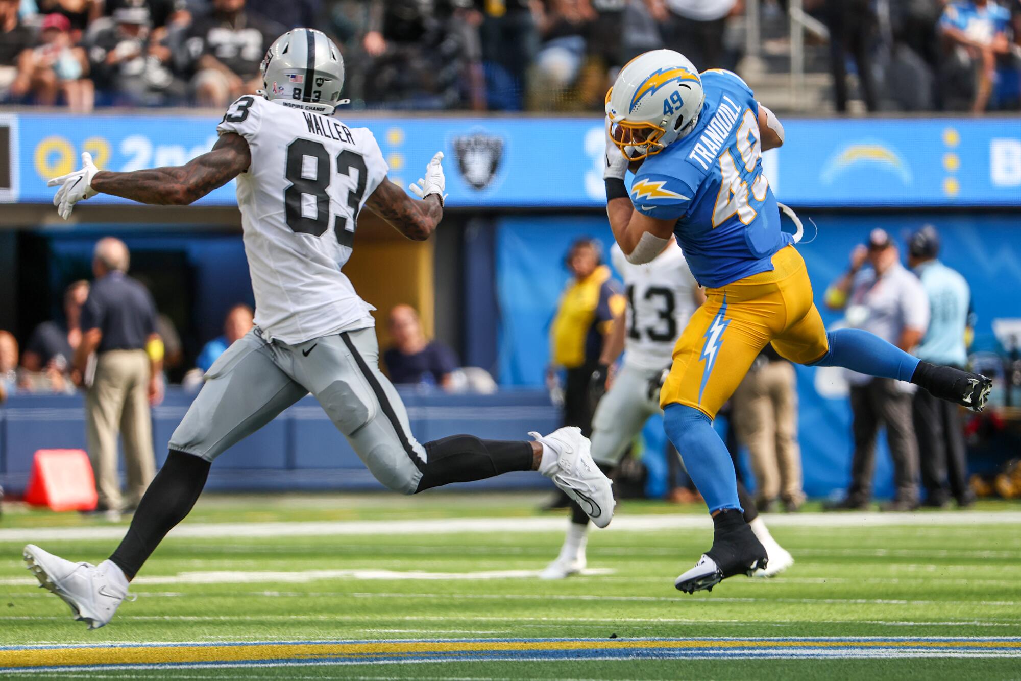 Chargers linebacker Drew Tranquill, right, intercepts a pass in front of Las Vegas Raiders tight end Darren Waller.