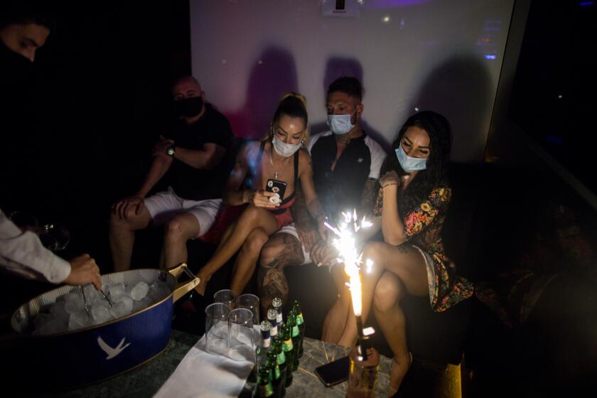 People wearing face masks to prevent the spread of coronavirus gather in a discotheque in Madrid, Spain, early Saturday, July 25, 2020. Nightlife is becoming the new target of Spanish authorities attempting to contain a spike in coronavirus infections since the country ended a lockdown. The Catalonia regional government has shut nightlife venues in Barcelona, and on Friday officials in Madrid said they were considering a similar step. (AP Photo/Manu Fernandez)