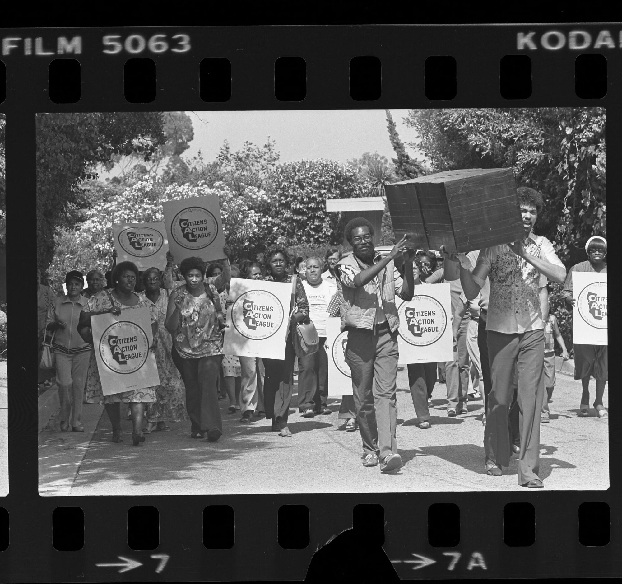 Protesters carry signs and a mock coffin up in Pacific Palisades where President Reagan's house was situated, in 1981.