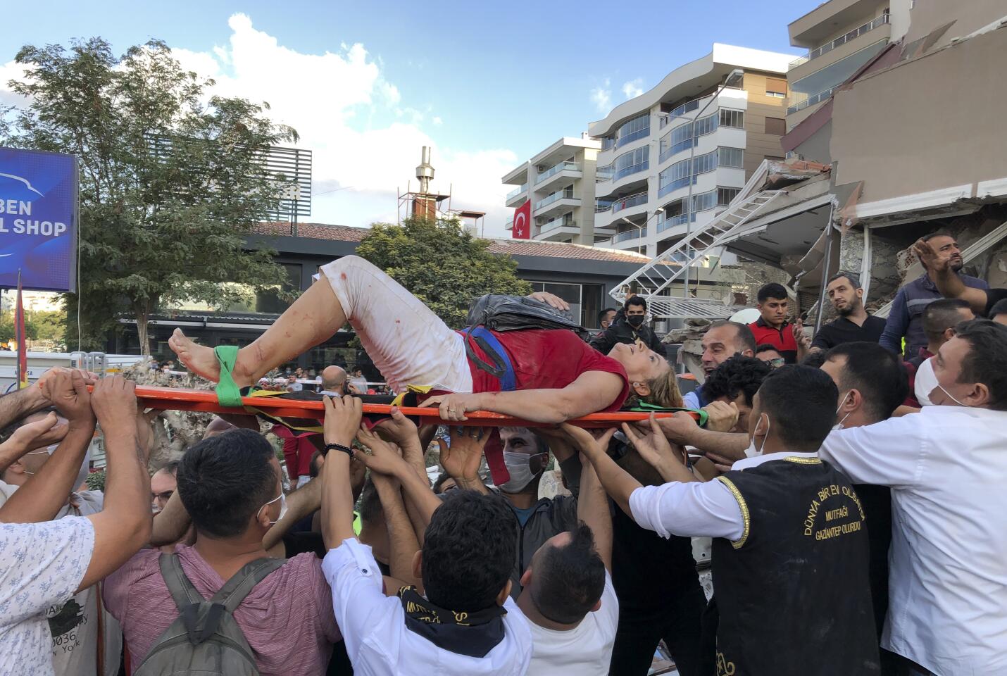 Rescue workers carry an injured person found in the debris in Izmir, Turkey