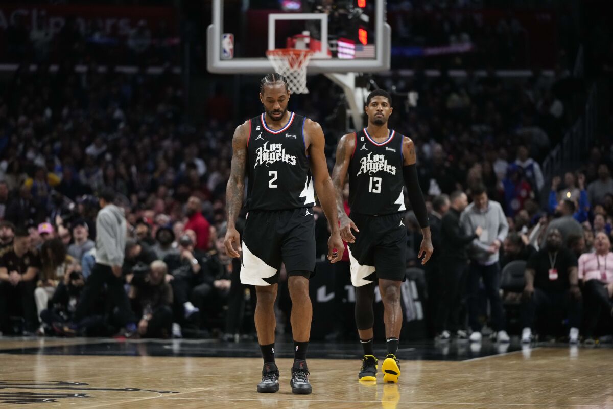 Clippers Kawhi Leonard (2) and Paul George (13) walk on the court during a March game against Golden State.
