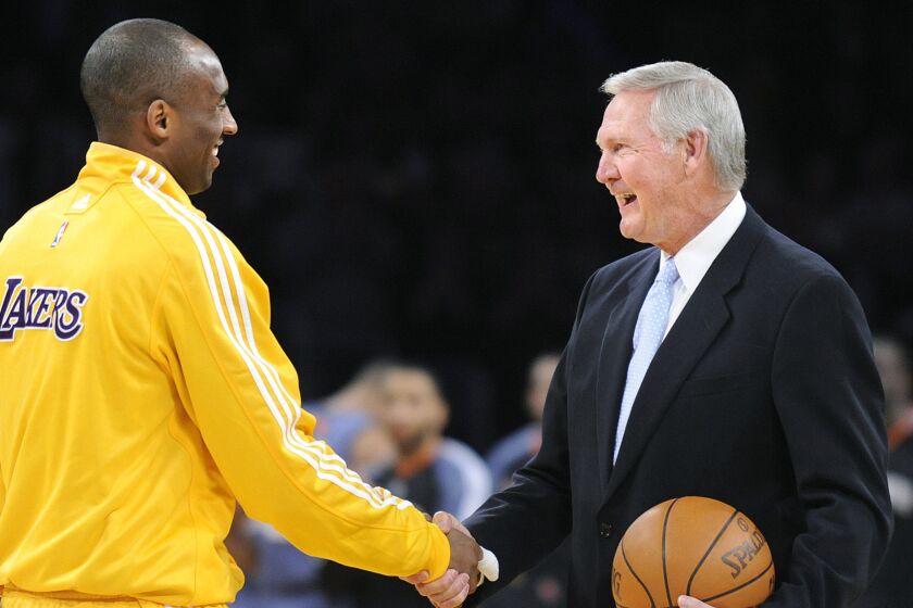 Lakers star Kobe Bryant shakes hands with Lakers legend Jerry West during a February 2010 ceremony to celebrate Bryant breaking the team record for most career points.