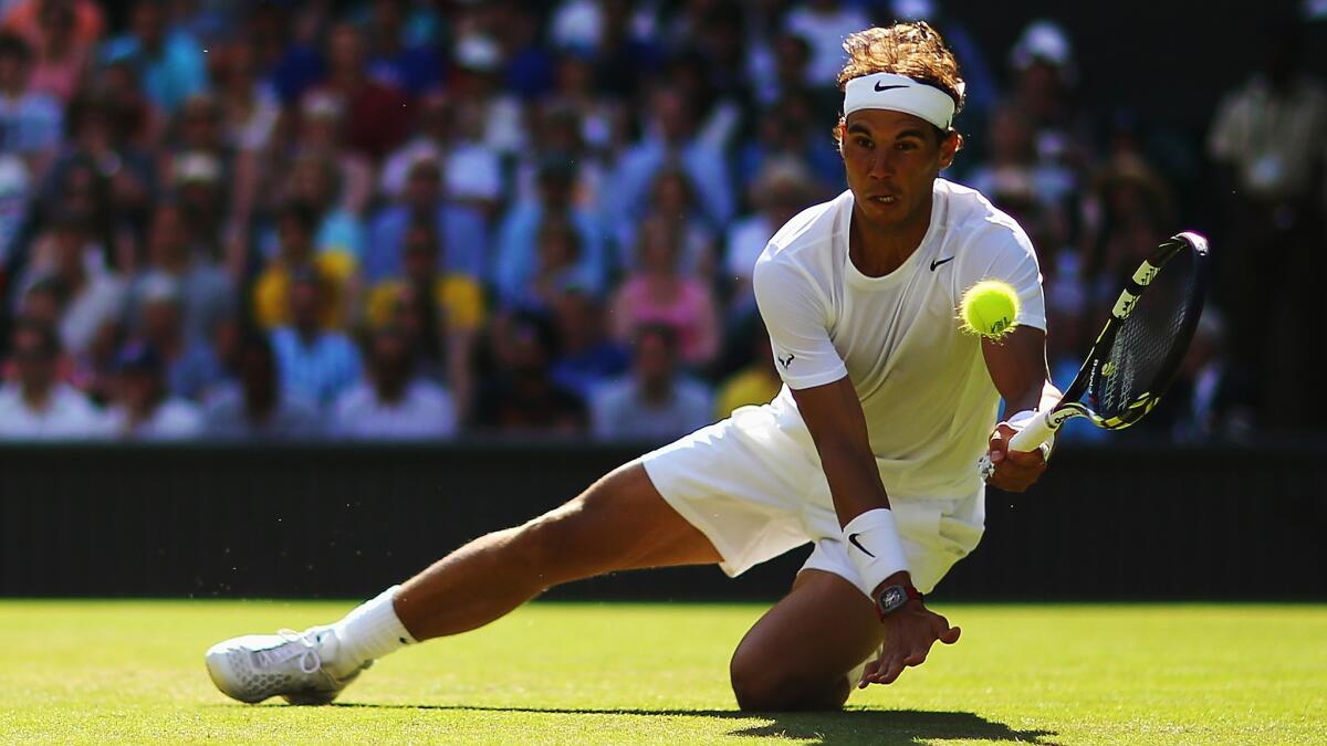 Rafael Nadal slides as he returns a shot during his first-round victory over Martin Klizan at Wimbledon on Tuesday.