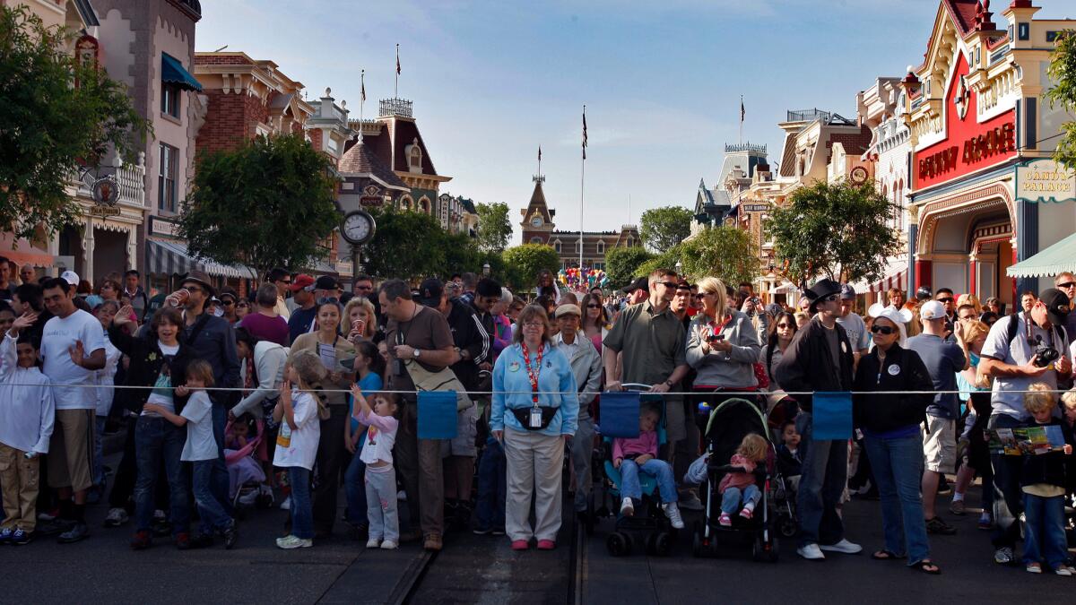 Crowds wait for entry to the Disneyland attractions on Main Street U.S.A. The park is reintroducing its Southern California annual passes at a higher price.