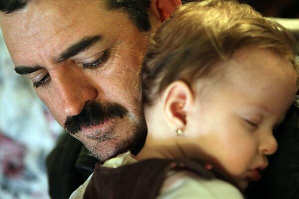 Miguel Romo holds his 6-month-old daughter, Virginia Bernice. Romo's wife died of pneumonia, believed to have been a complication of the H1N1 virus she caught last spring at the dawn of the outbreak. Romo's death in many ways typifies the pandemic: She was young, poor, pregnant and Latina.