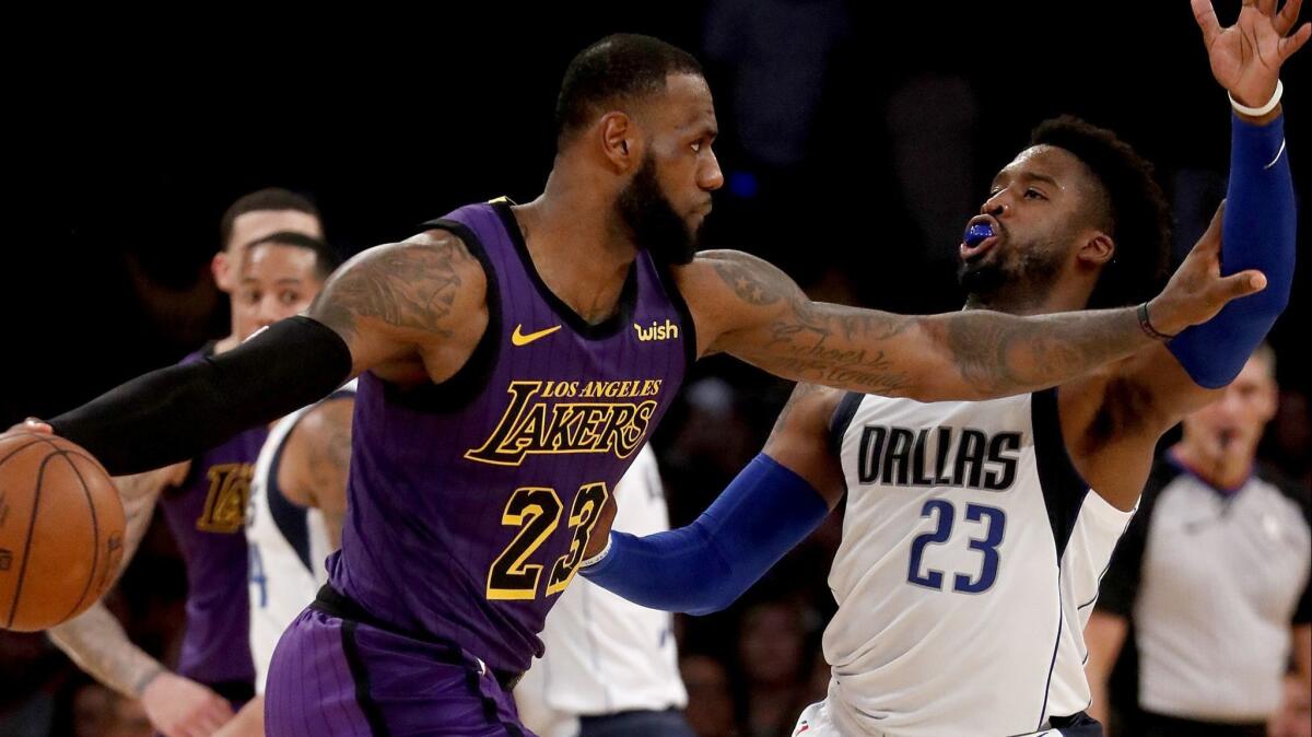 Lakers forward LeBron James parries with Dallas Mavericks guard Wesley Matthews in the fourth quarter on Friday at Staples Center.