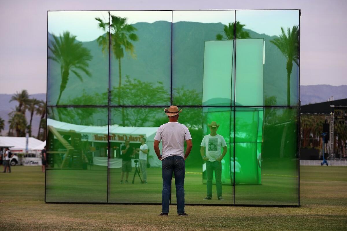 A festival-goer gazes into the art installation "Reflection Field," by Phillip K. Smith, at the Coachella Music and Arts Festival in Indio, Calif.