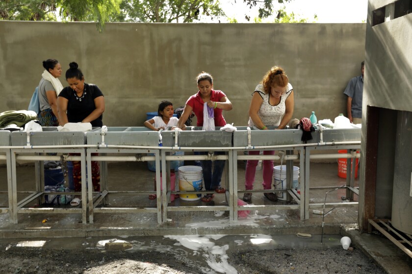 Migrants wash their clothes in a facility at the Matamoros refugee camp
