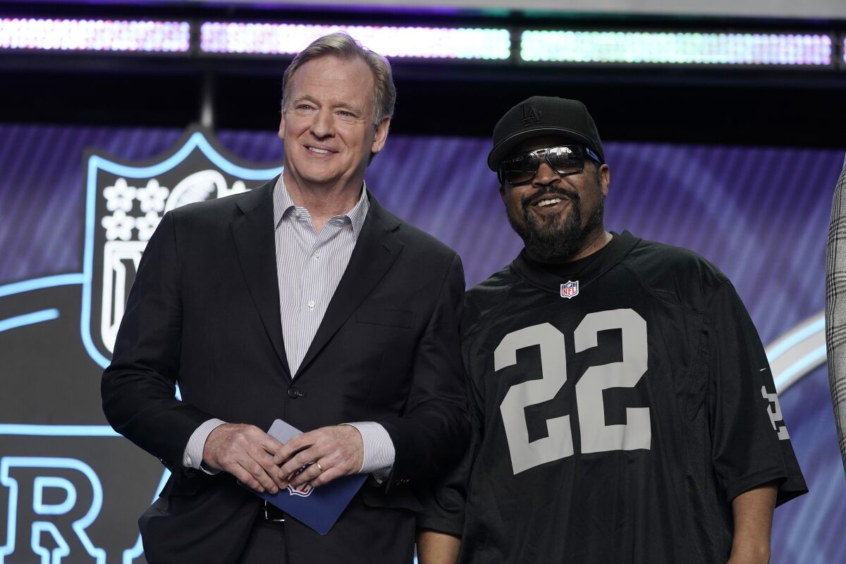 ARCHIVO - El rapero Ice Cube (derecha) posa con el comisionado de la NFL Roger Goodell durante la primera ronda de la NFL, 