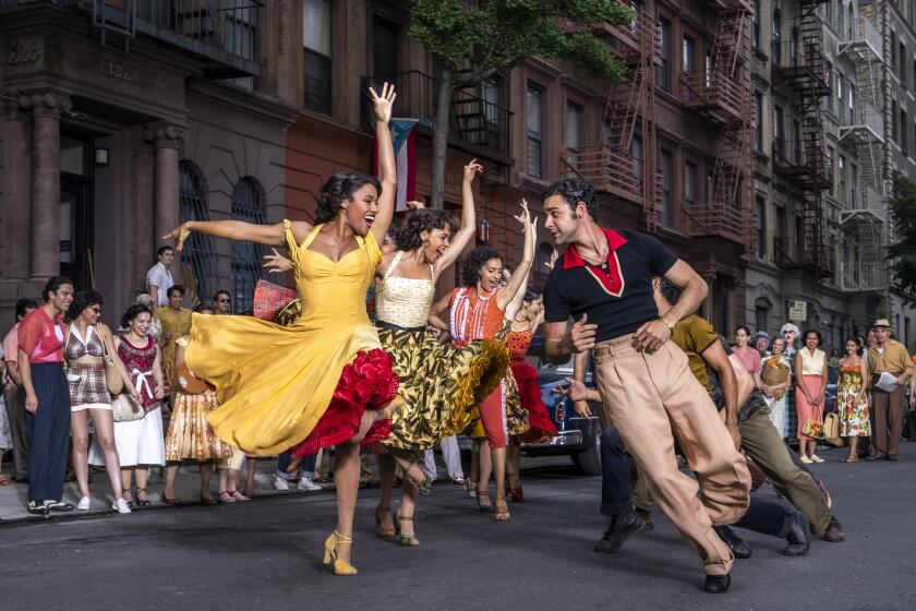 A group of people dancing on a street in colorful outfits