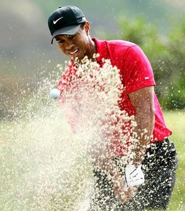 Woods hits out of a greenside bunker on the 4th hole during the playoff.