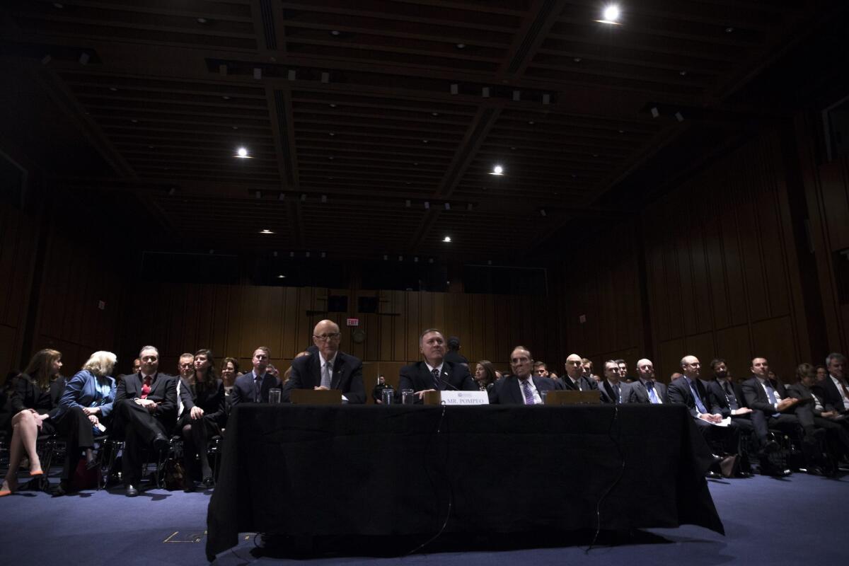 CIA director nominee and Congressman from Kansas Michael Pompeo, center, with Republican senator from Kansas Patrick Roberts, left, and former Republican senator from Kansas Bob Dole sit at the witness table after the hearing room lights went out during his confirmation hearing before the Senate Intelligence Committee on Capitol Hill on Jan. 12, 2017.