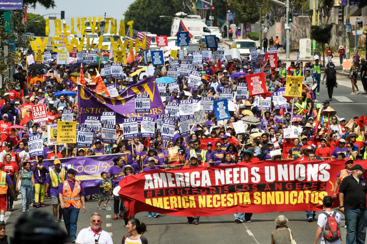 Demonstrators march through downtown Los Angeles during a Labor Day protest organized by the SEIU in support of a $15 per hour wage.