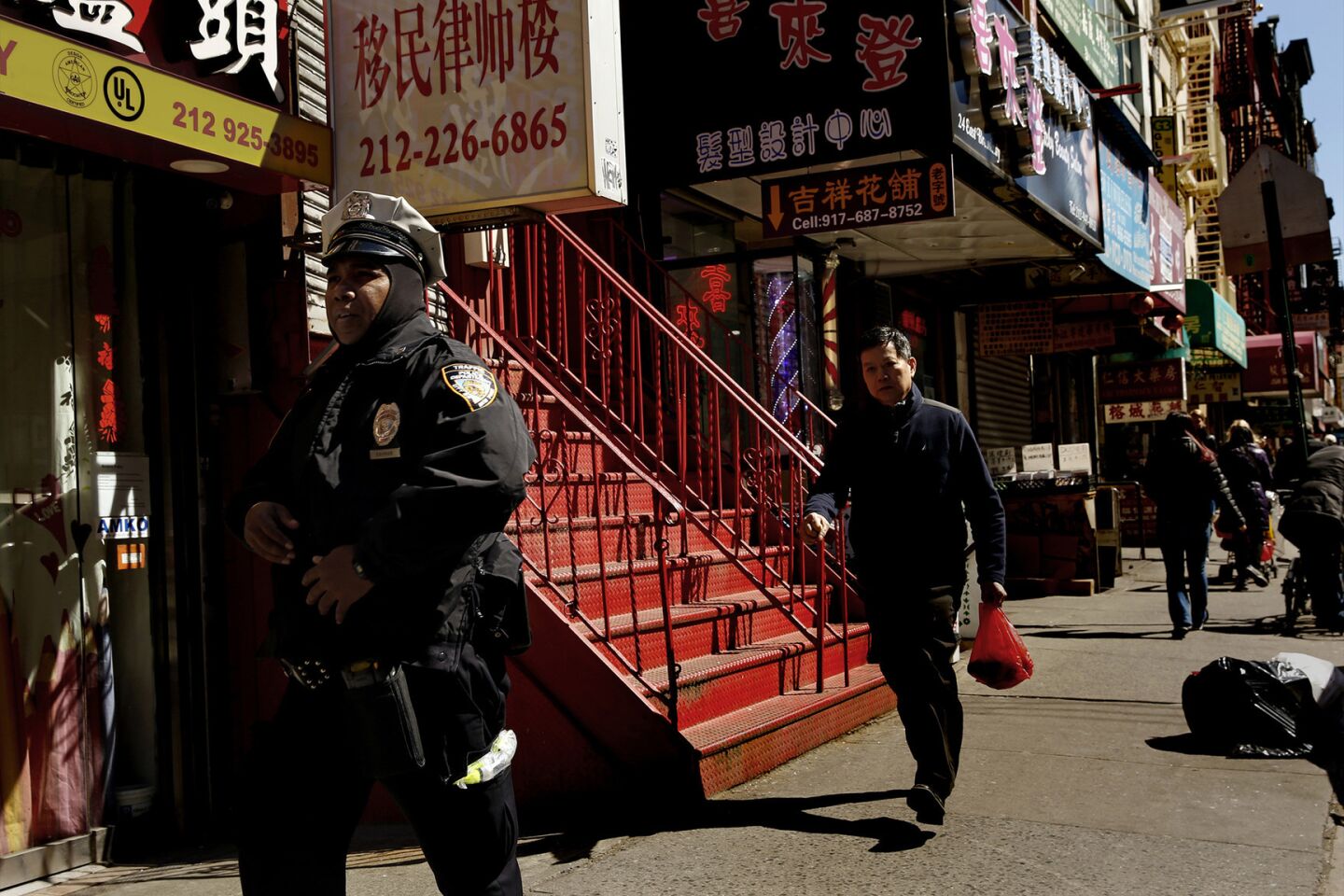A police officer patrols on the edge of New York's Chinatown.