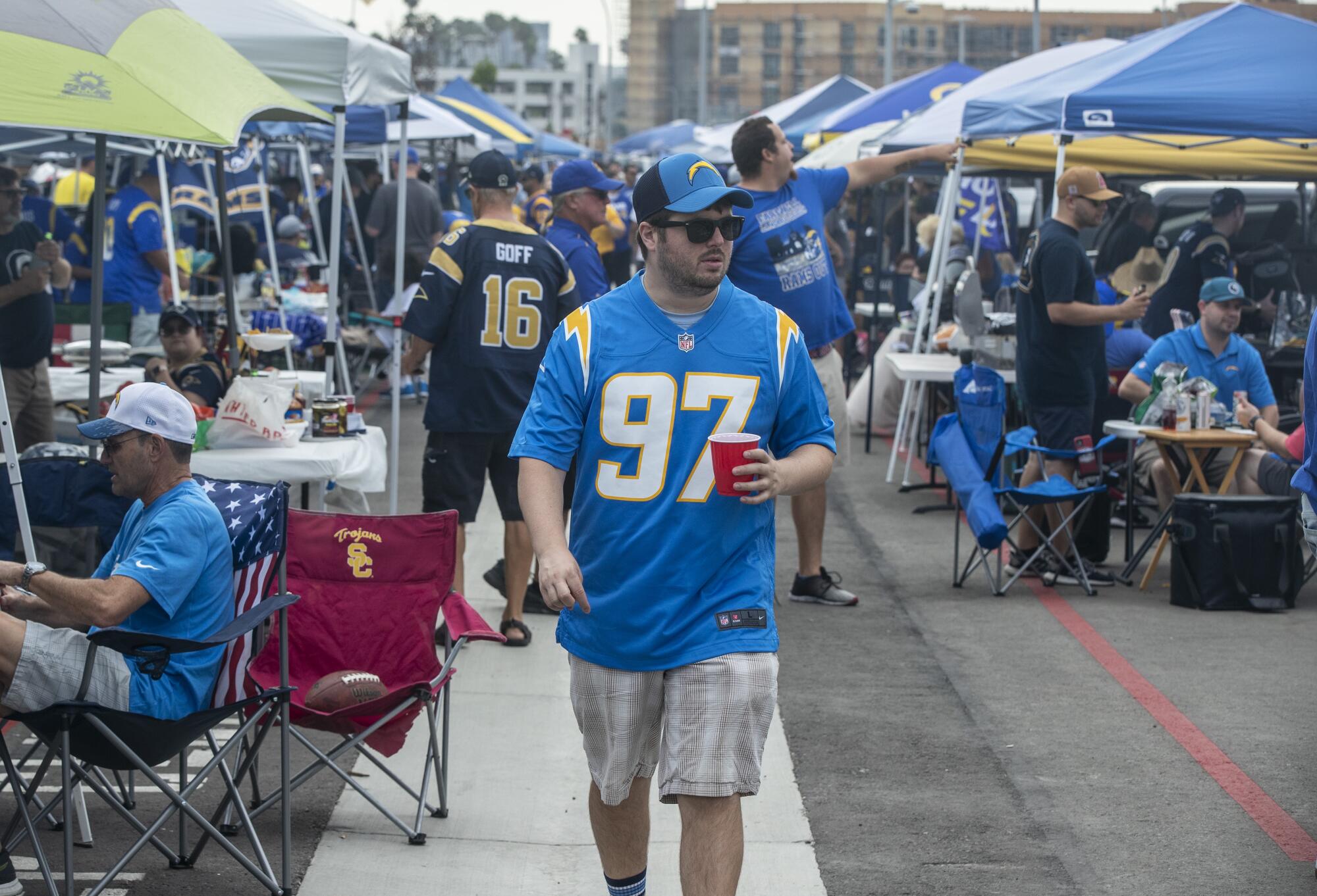 A Chargers fan walks through Rams territory.