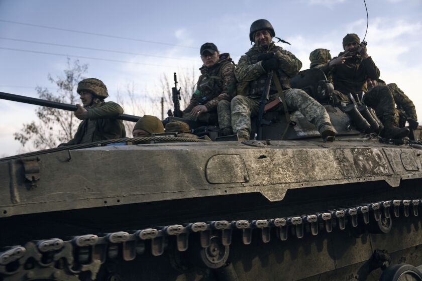 Ukrainian soldiers ride atop an APC on the frontline in Bakhmut, Donetsk region, Ukraine, Wednesday, March 22, 2023. (AP Photo/Libkos)