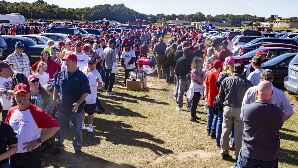 Supporters line up Saturday to board buses to President Trump's rally in Pensacola, Fla.