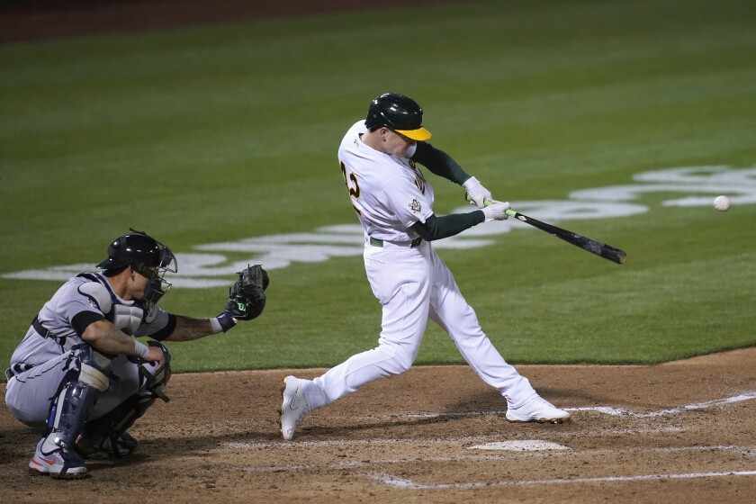 Oakland Athletics' Matt Chapman hits a two-run double in front of Detroit Tigers catcher Wilson Ramos during the sixth inning of a baseball game in Oakland, Calif., Thursday, April 15, 2021. (AP Photo/Jeff Chiu)