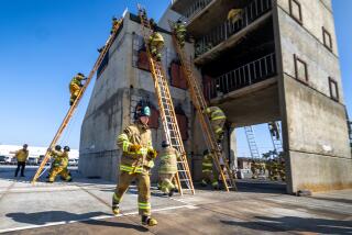 Huntington Beach, CA - October 02: Firefighter recruit captain Jacob Hulick runs back to his ladder after climbing up and down ladders on a training building during ladder training at the Santa Ana Basic Fire Academy at Central Net Joint Powers Training Center in Huntington Beach Wednesday, Oct. 2, 2024. (Allen J. Schaben / Los Angeles Times)