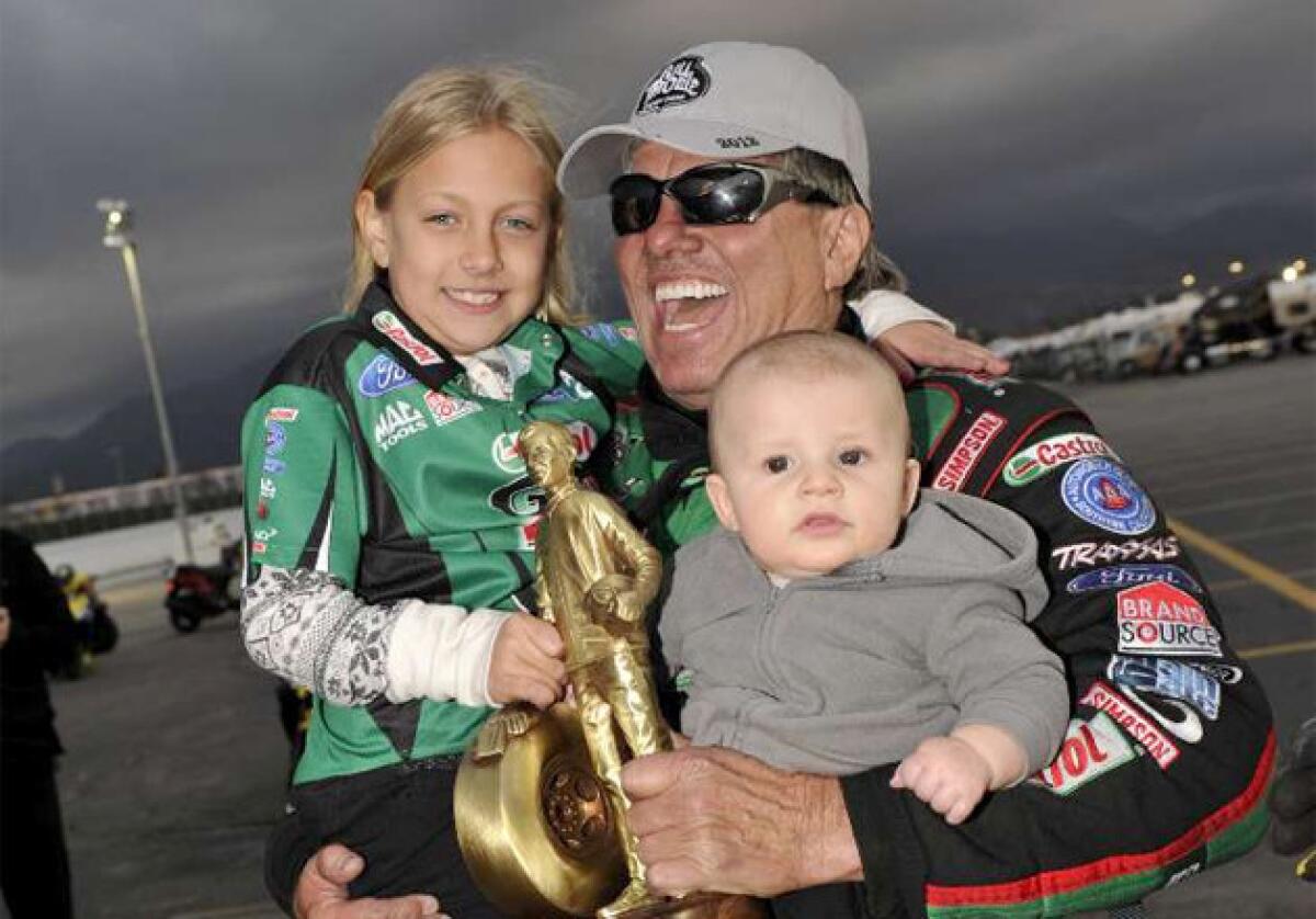 John Force celebrates earning his 134th career win at the NHRA Winternationals drag races with his grandchildren.