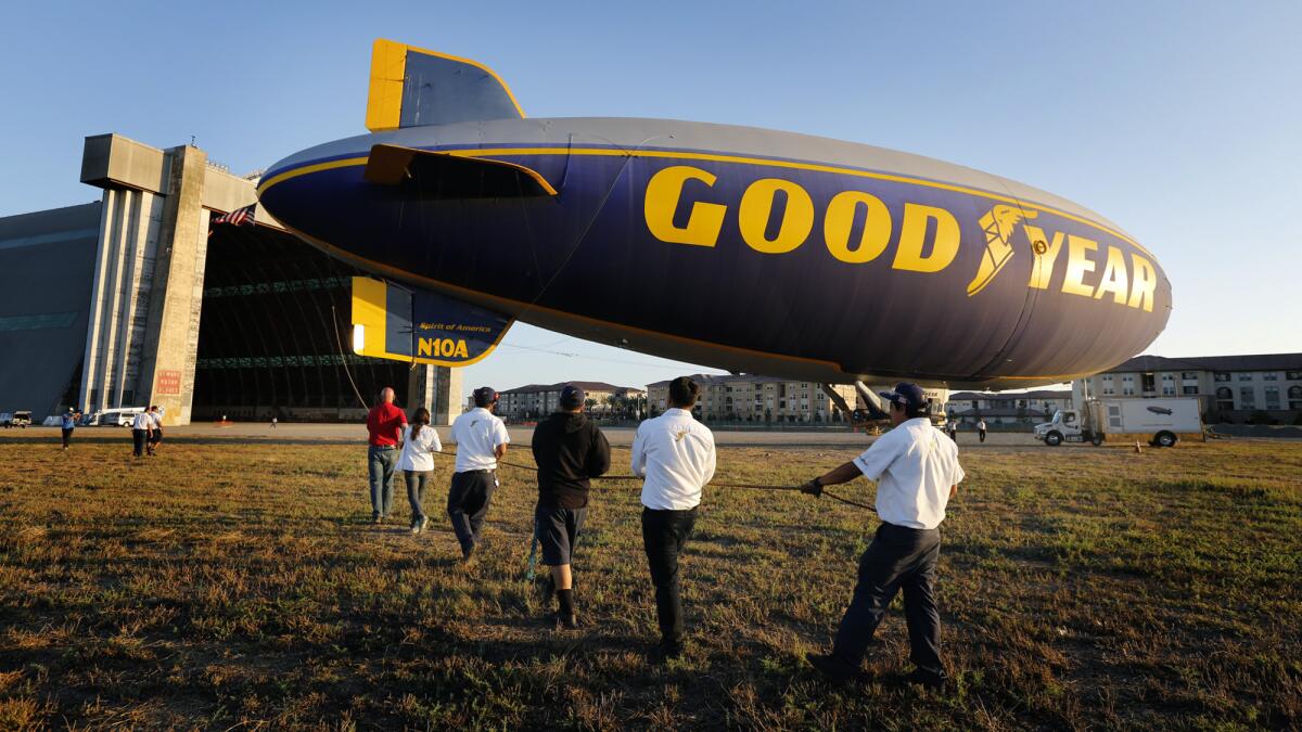 Crew members hold a rope tied to the back of Spirit of America as a truck moves the front of the airship toward a huge World War II-era hangar in Tustin, where it would be decommissioned.
