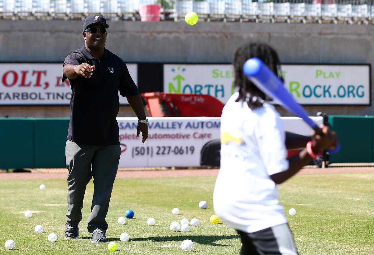Tony Reagins coaches children during a 2018 MLB youth event in North Little Rock, Ark.