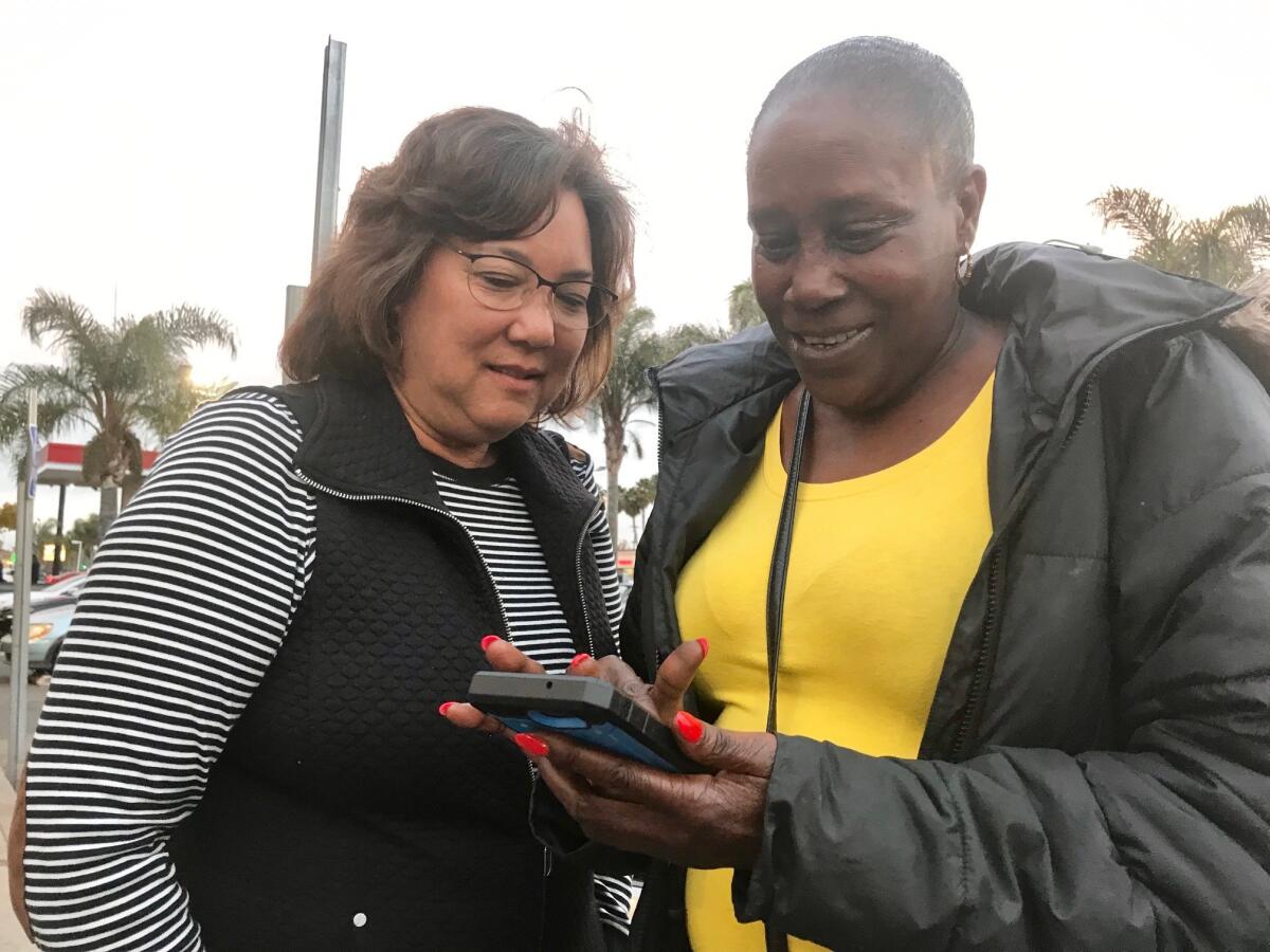 Gayle Coyle-Ikemoto, left, and Linda Huff look at photos of Huff's grandchildren. Coyle-Ikemoto is a court-appointed advocate for one of the kids.