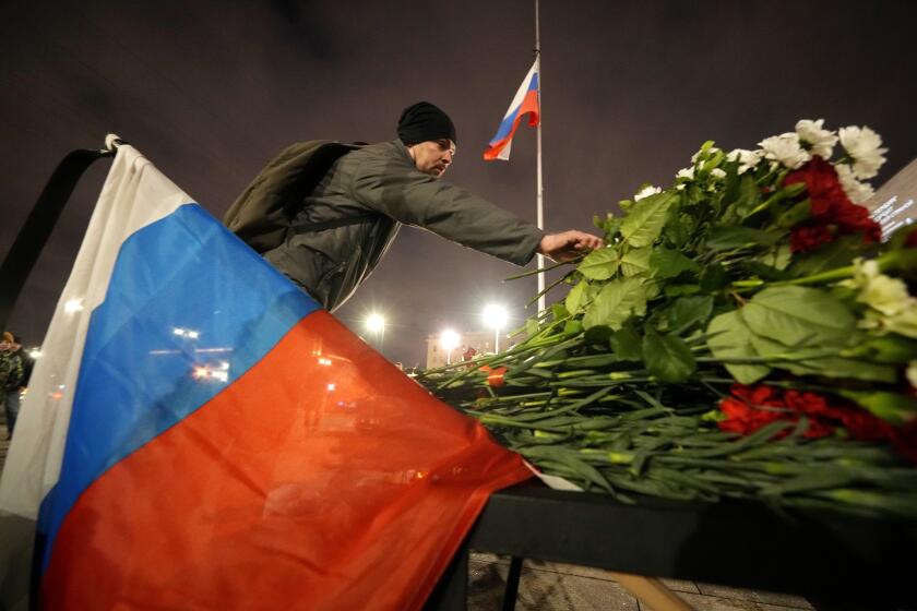 Un hombre coloca flores en un altar improvisado a las víctimas del ataque en Moscú, en San Petersburgo, Rusia, el sábado 23 de marzo de 2024. (AP Foto/Dmitri Lovetsky)