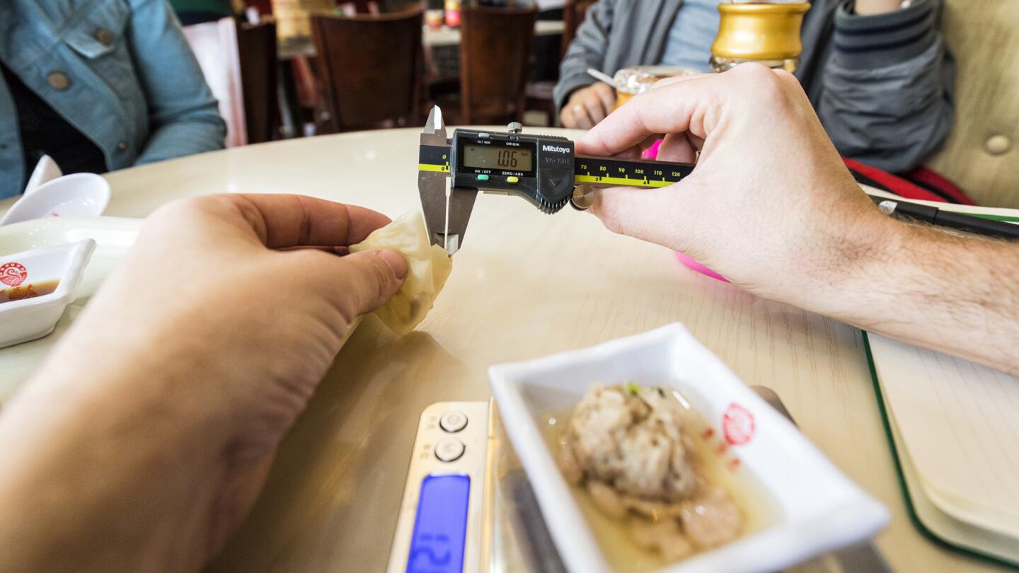 Christopher St. Cavish checks the skin of a soup dumpling with digital calipers capable of measuring 1/100th of a millimeter at Zun Ke Lai restaurant in Shanghai.
