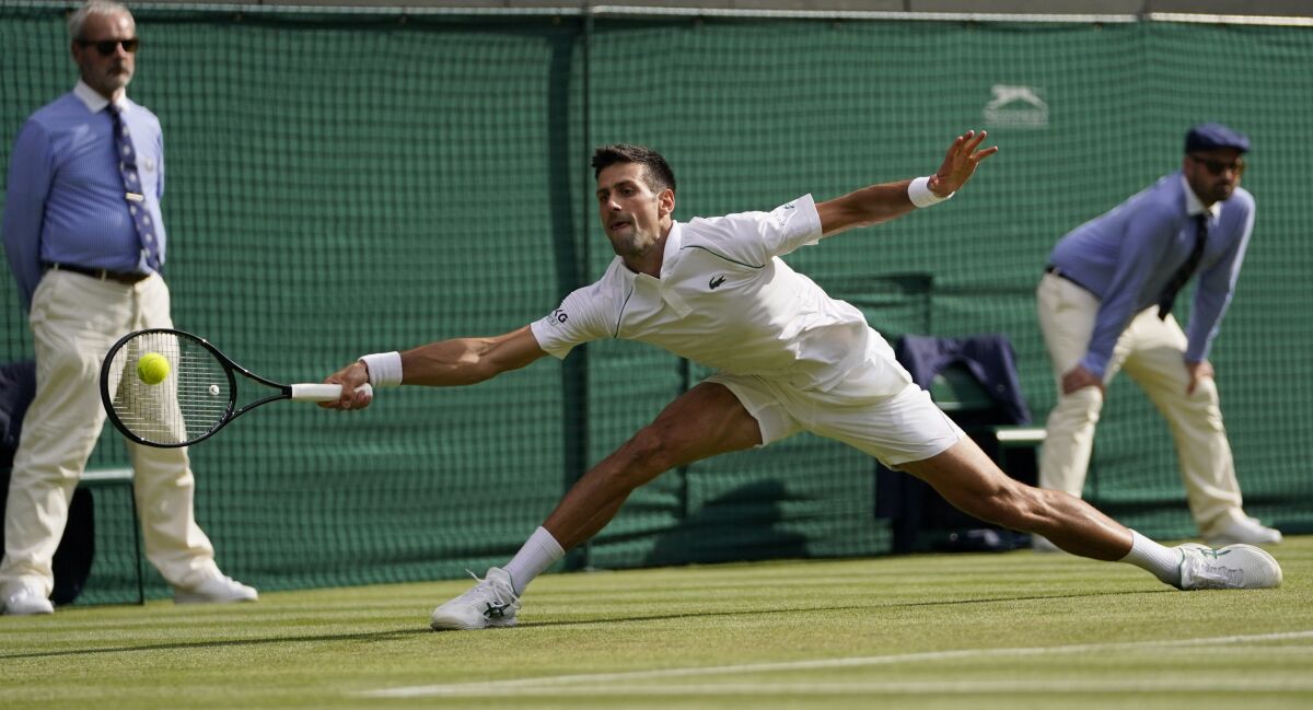 Serbia's Novak Djokovic plays a return to Denis Kudla of the US during the men's singles third round match on day five of the Wimbledon Tennis Championships in London, Friday July 2, 2021. (AP Photo/Alberto Pezzali)
