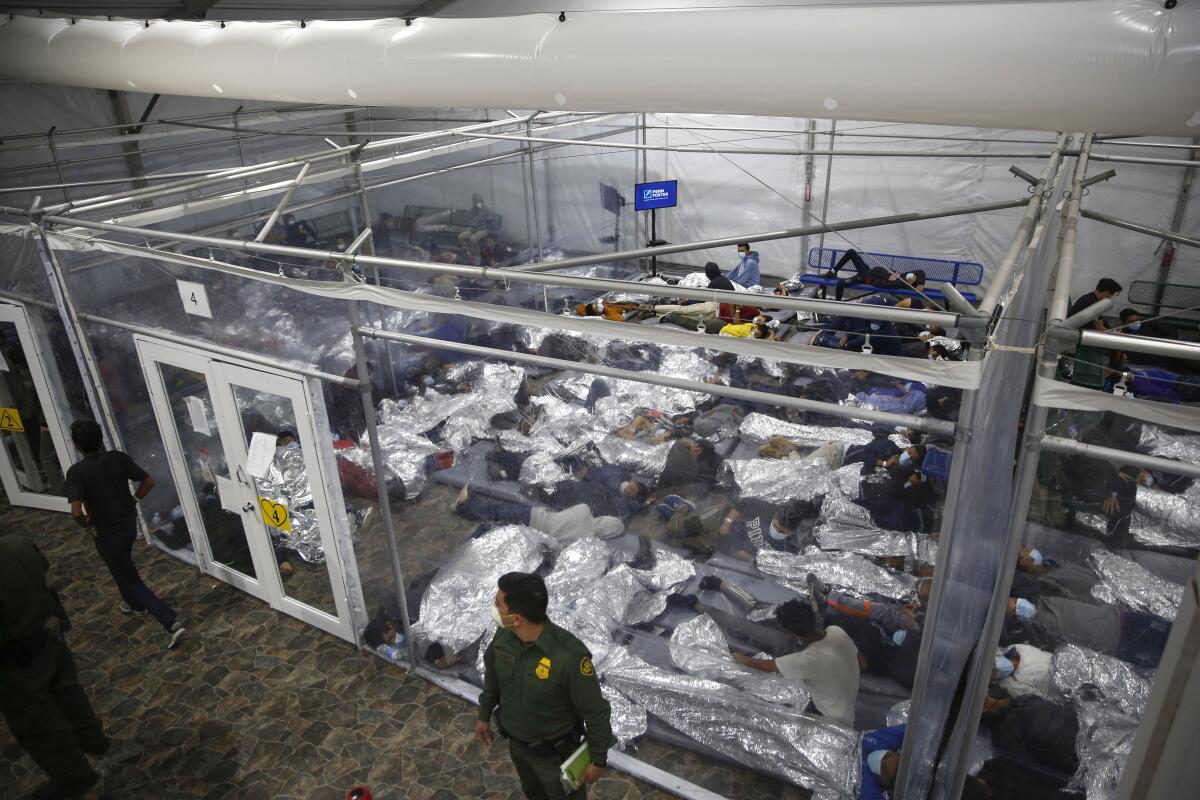 ARCHIVO - Niños acostados dentro de una celda en el principal centro de detención para niños no acompañados en Rio