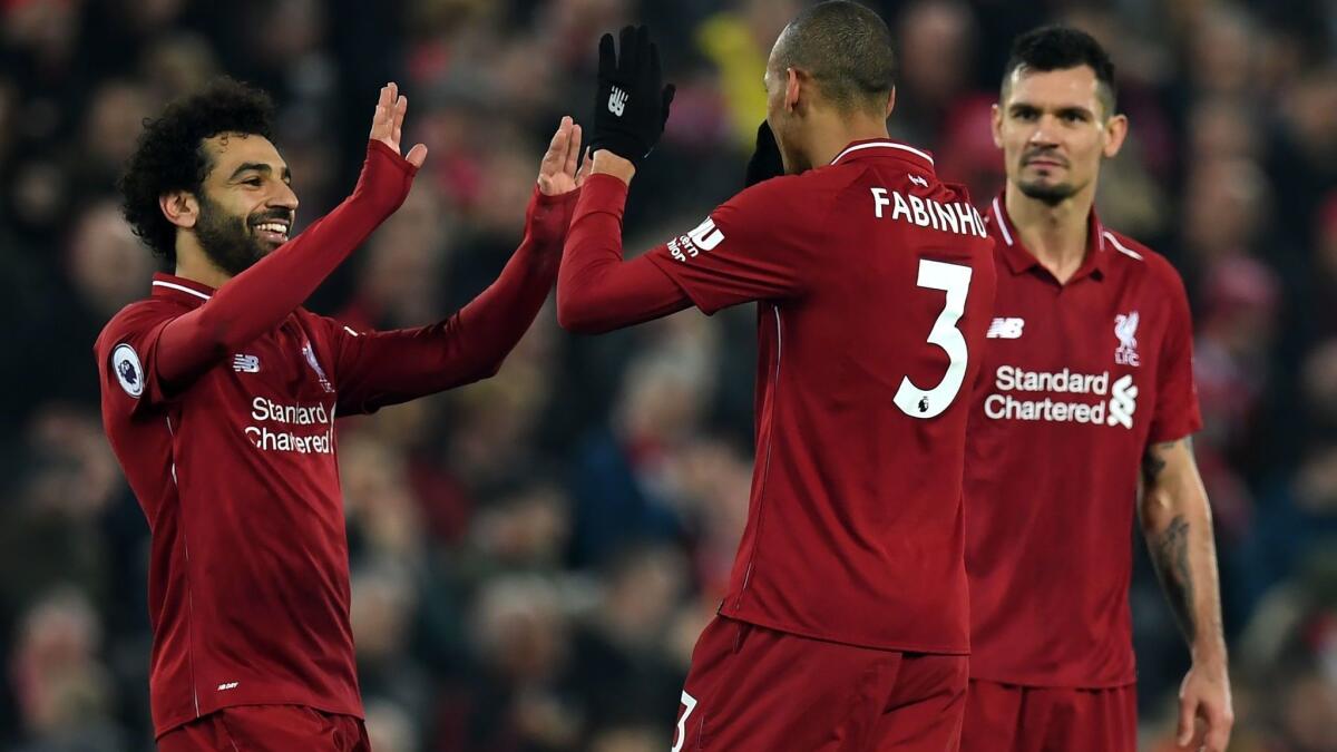 Liverpool's midfielder Fabinho, center, celebrates with midfielder Mohamed Salah, left, and defender Dejan Lovren after he scores their fourth goal during the English Premier League match between Liverpool and Newcastle United on Wednesday.