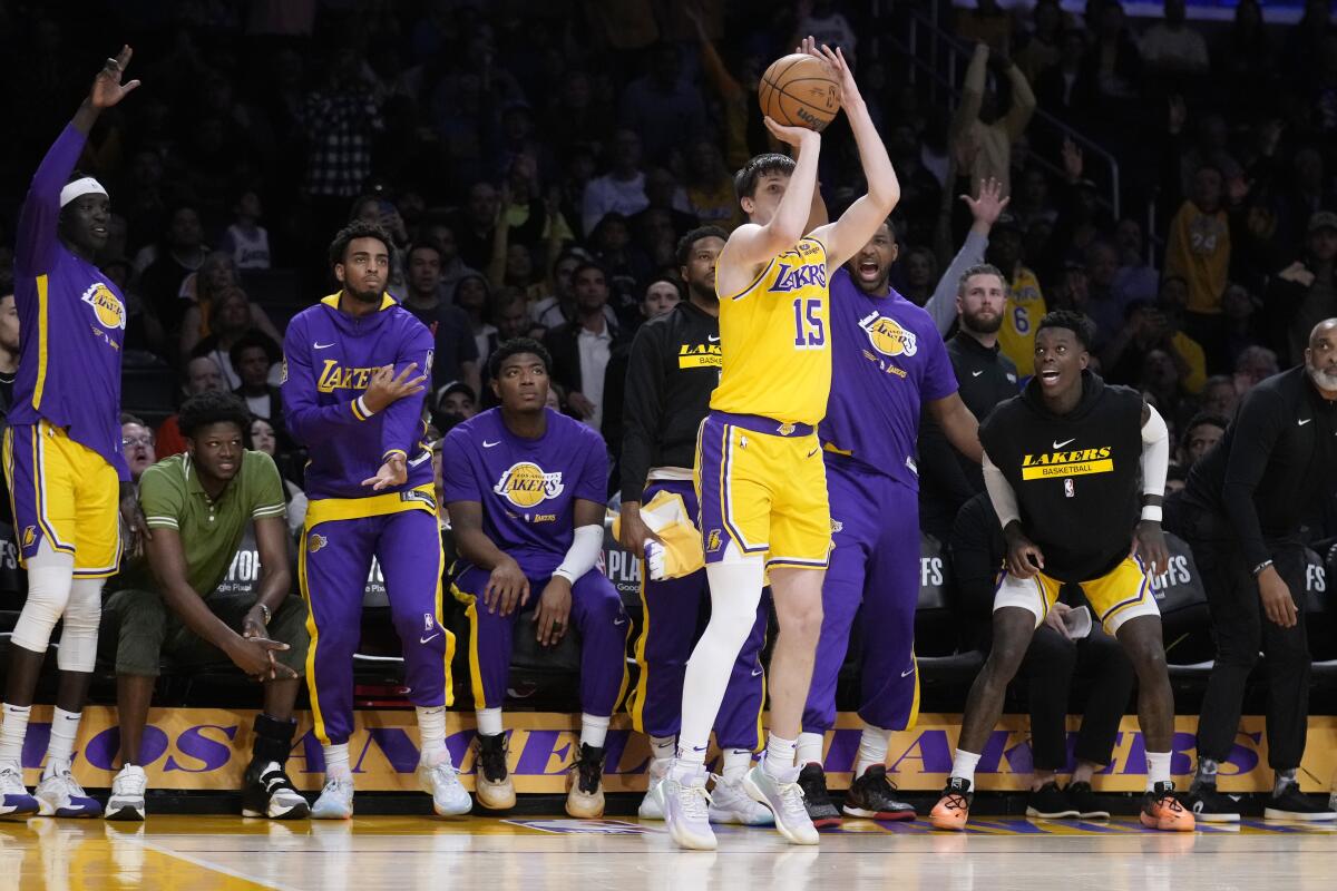 Lakers guard Austin Reaves shoots from the corner as teammates watch intently from the bench during second half of Game 4.