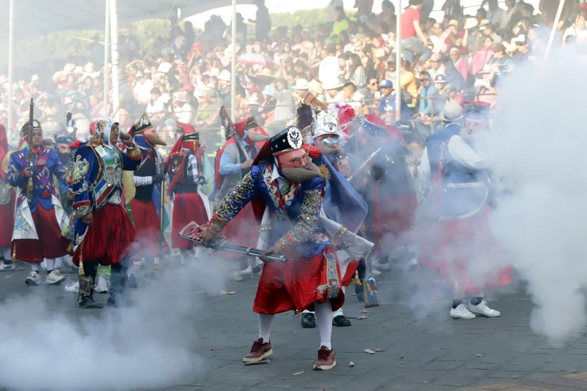 Batallones de distintos barrios con trajes típicos participan este sábado, en un carnaval en el municipio de Huejotzingo en el estado de Puebla (México).